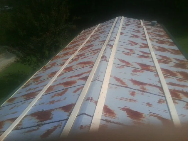 Rusted metal roof panels with new wood purlins before replacement — Storm Damage Roof Repair in Greenbrier by Roofing Brothers