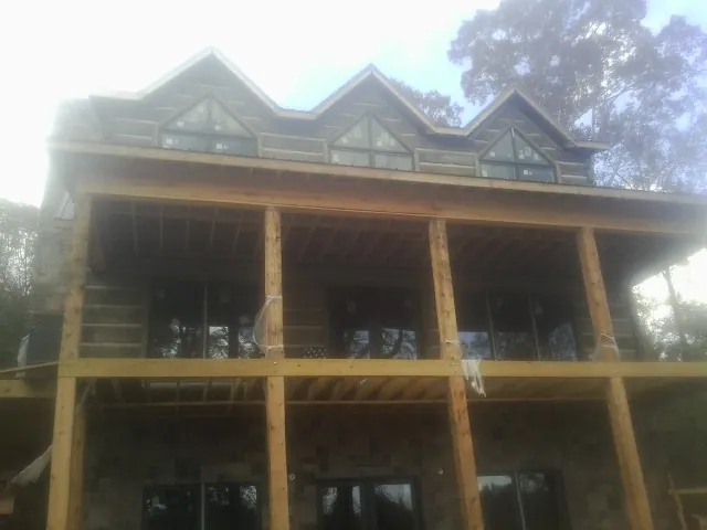 Dormers and porch framing on a large log home under construction — Roof Coating work by our crew in Greenbrier