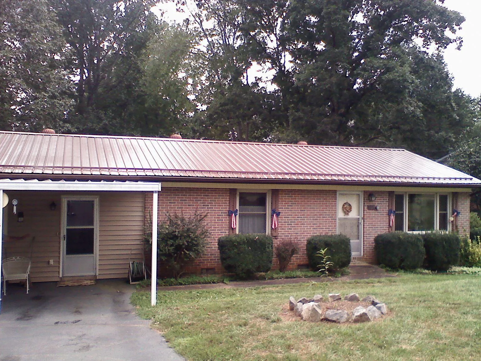 Bronze metal roof and carport on a brick ranch home — Roof Repair work by our crew in Greenbrier